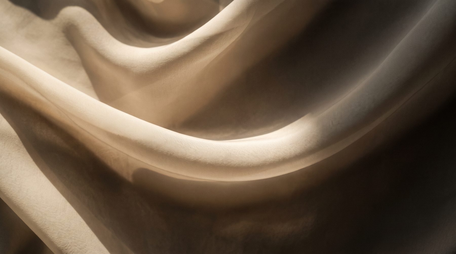 Soft folds of warm ivory silk lit from the side